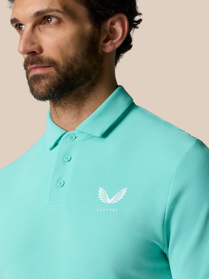 Close up of light aqua Golf Club Essential Polo with pointed collar and Castore logo on chest.