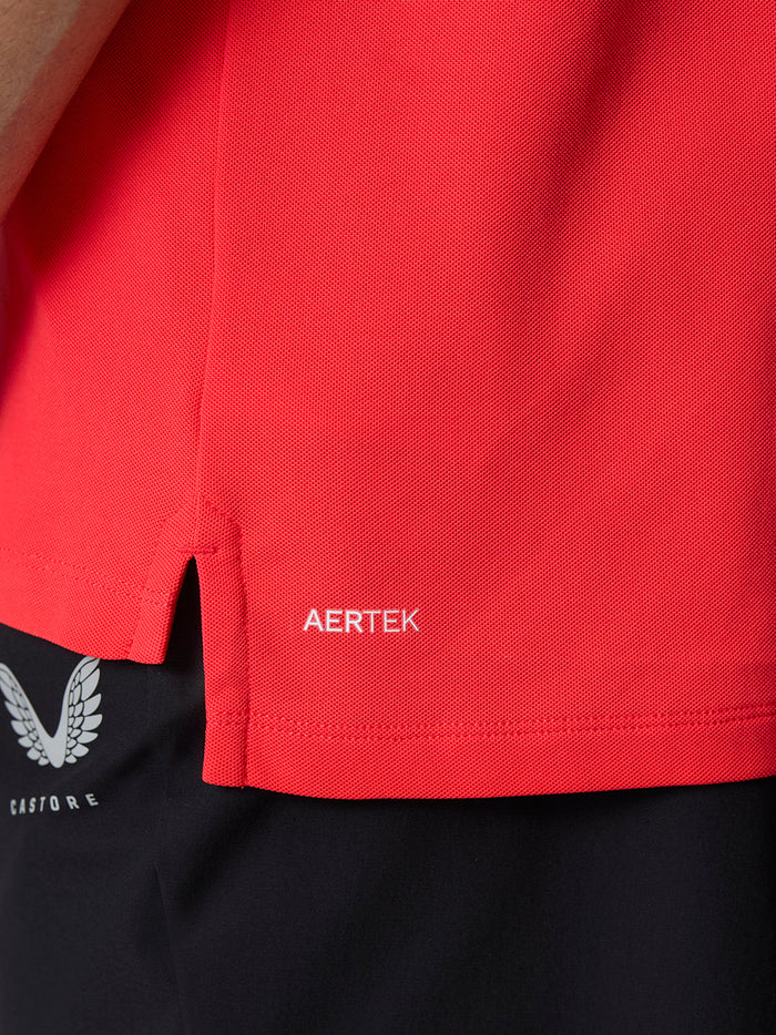 Close up of the polo hem showing AERTEK branding near a small side slit.