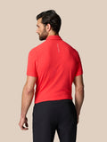 Rear view of man in red Golf Club Essential Polo showing vertical Castore branding on upper back.