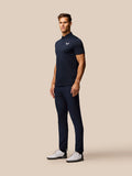 Male model wearing navy Pinnacle Pique Stripe Polo with striped pattern and Castore logo on left chest