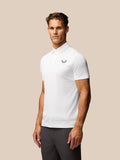 Male model wearing Golf Pinnacle Pique Stripe Polo in white with subtle stripes and Castore logo on chest.