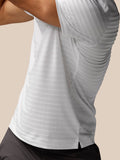 Close-up of white textured pique stripe polo fabric with a side hem split detail.
