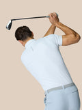 Back view of a man in a white polo swinging a golf club, Castore logo on the upper back