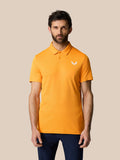 Male model in a bright mango Golf Pinnacle Polo with a pointed collar and Castore logo on the chest