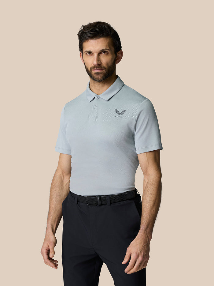 Male model wearing a light grey Golf Pinnacle Polo with short sleeves and a chest logo.