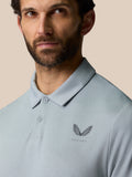 Close up of a man wearing a mid grey golf polo with a small chest logo.