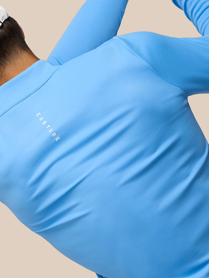 Left chest Castore logo on Cool Blue 1/4 Zip Top worn by a golfer.