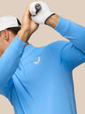 Golfer wearing Cool Blue 1/4 Zip Top with Castore logo and white glove raised during a swing.