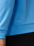 Man in light blue Golf Club Classic quarter zip top with stand-up collar front zipper white golf shoes and black trousers