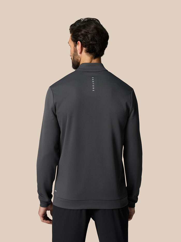 Back view of a man in a gunmetal golf club classic quarter zip top showing Castore branding along the upper back