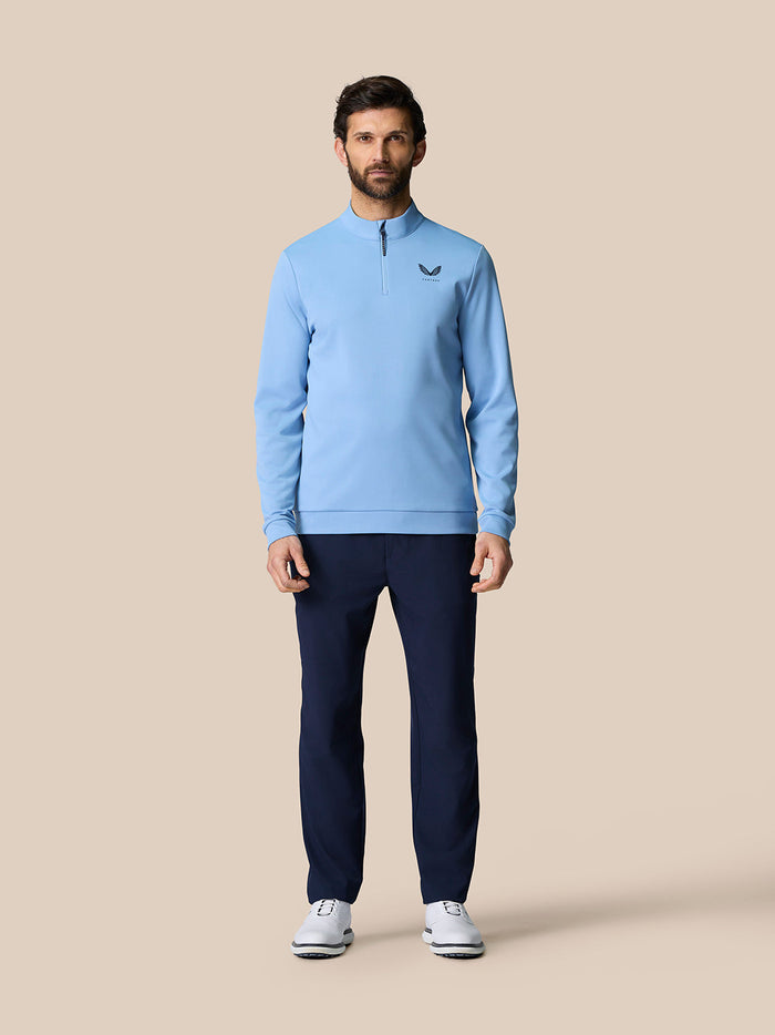 Male model wearing sky blue golf quarter zip top with stand collar and front zip