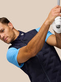Male model wearing midnight navy Pinnacle Golf Gilet with sleeveless design and full front zip posing with a golf club