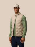 Model wearing mushroom Golf Pinnacle lightweight quilted gilet over sage green top.