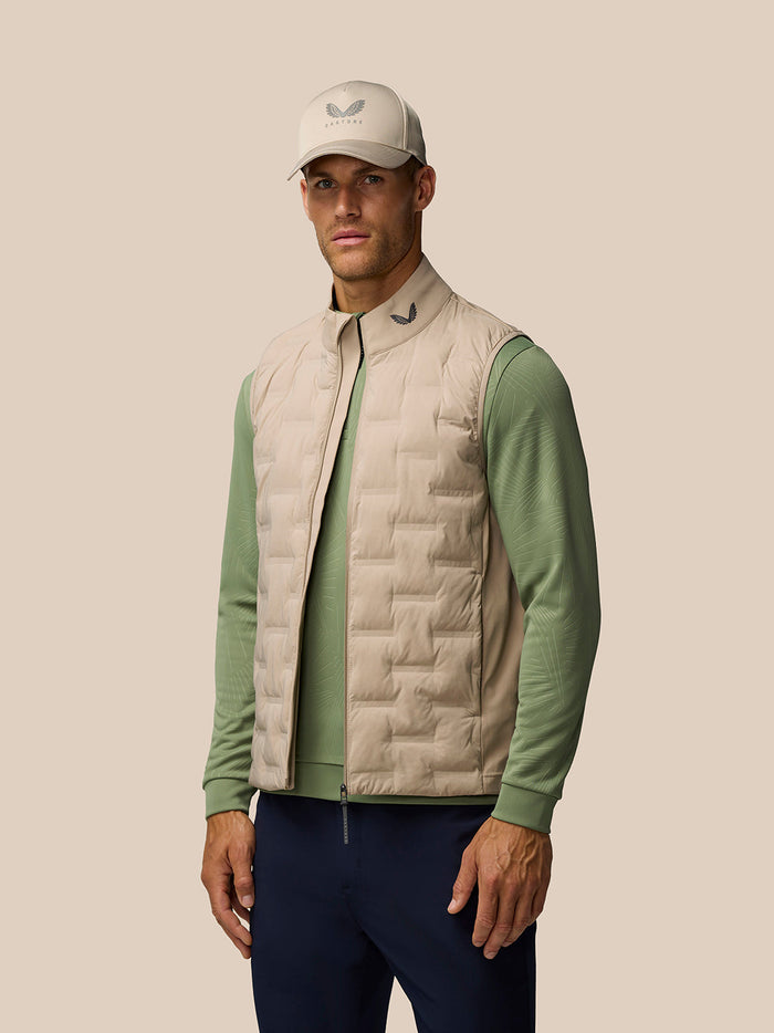 Model wearing mushroom Golf Pinnacle lightweight quilted gilet over sage green top.
