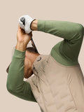 Golfer in Mushroom Golf Pinnacle Lightweight Hybrid Gilet with quilted front raising a club in a dynamic pose