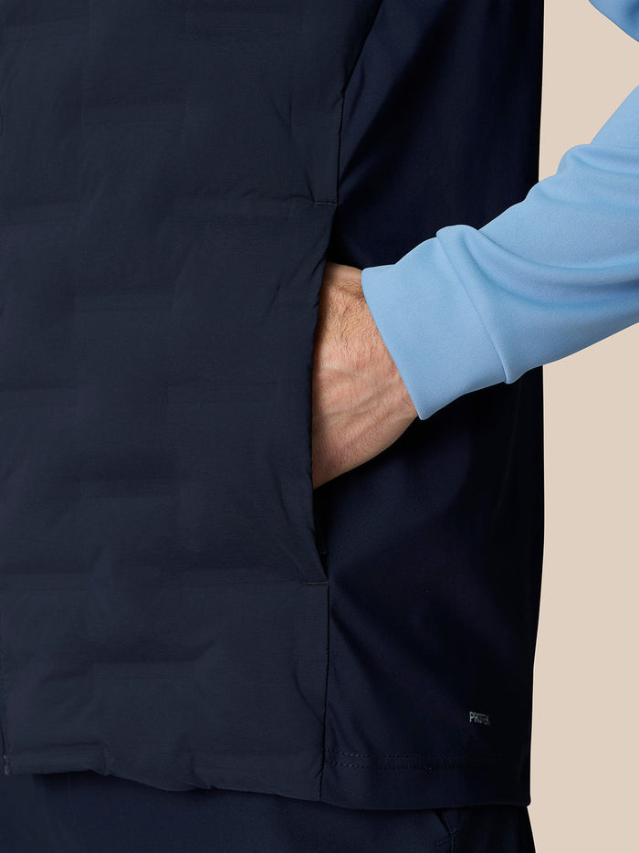 Side view of navy Pinnacle Gilet with hand in pocket and subtle Protek detailing at hem.
