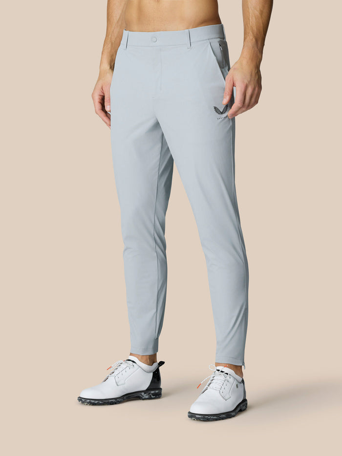 Model wearing light blue Golf Pinnacle 34 inch trousers with Castore logo on thigh and white sneakers