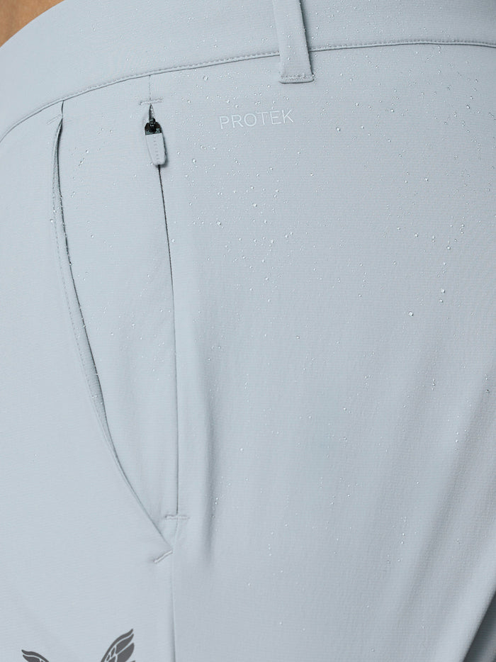 Close-up of back pocket area on light grey Golf Pinnacle trousers with ProTek branding and water droplets