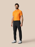 Male model in black Golf Pinnacle 34 inch trousers with logo on right thigh and cuff zips
