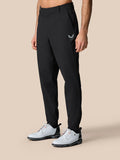 Male model wearing black golf trousers with logo on the right thigh and zip cuffs