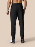 Back view of black golf trousers showing a logo on the right rear and elastic cuffs