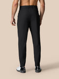 Back view of black Golf Pinnacle trousers with secure waistband and tapered cuffs shown with white sneakers