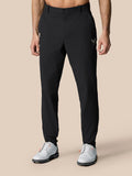 Front view of man in black Golf Pinnacle trousers with belt and white golf shoes.