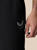 Close-up of Castore logo and wing emblem on black Golf Pinnacle trousers at the thigh