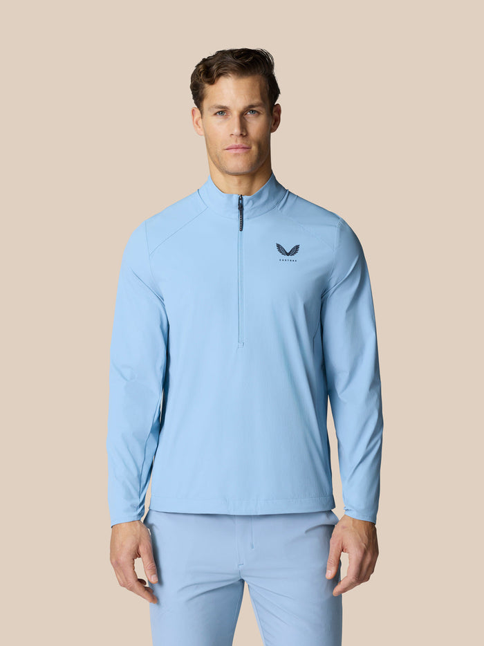 Male model in sky blue Flex jacket with high funnel neck and half zip; Castore logo on chest