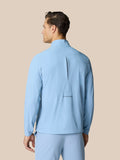Back view of sky blue Flex jacket showing back vent and Castore branding