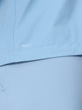 Close-up of water beading on sky blue Flex Jacket fabric showing ProTek water resistance.