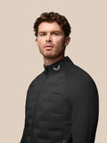 Full body side view of a male model wearing a black Golf Pinnacle Jacket with stand collar and zip pockets