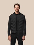 Male model wearing black Golf Pinnacle Jacket with quilted front panels stand collar and front zip.