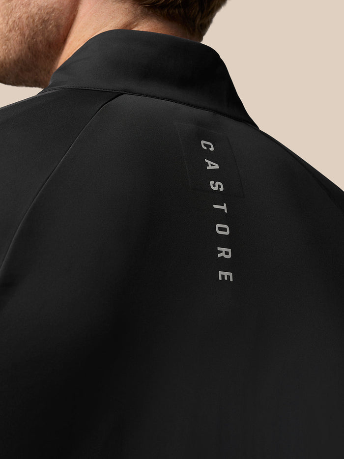 Back view of black Golf Pinnacle Jacket with vertical Castore branding along the upper back