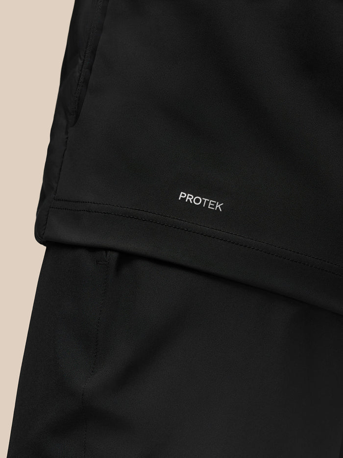 PROTEK branding on the lower hem of the black Golf Pinnacle Jacket