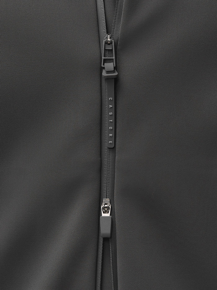 Close up of zipper and seam on dark jacket fabric with CASTORE branding on the zipper pull.