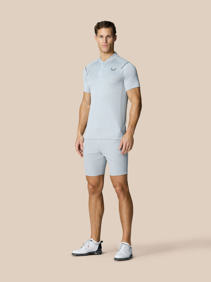 Model in light grey Pinnacle Golf LVS Polo with matching shorts, highlighting breathable engineered knit and mesh panels.
