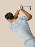Golfer wearing light grey Pinnacle Golf LVS Polo mid swing with vent panels and side split hems.