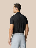 Back view of man in a black Club Graphic Polo showing golf ball pattern and Castore branding along the back