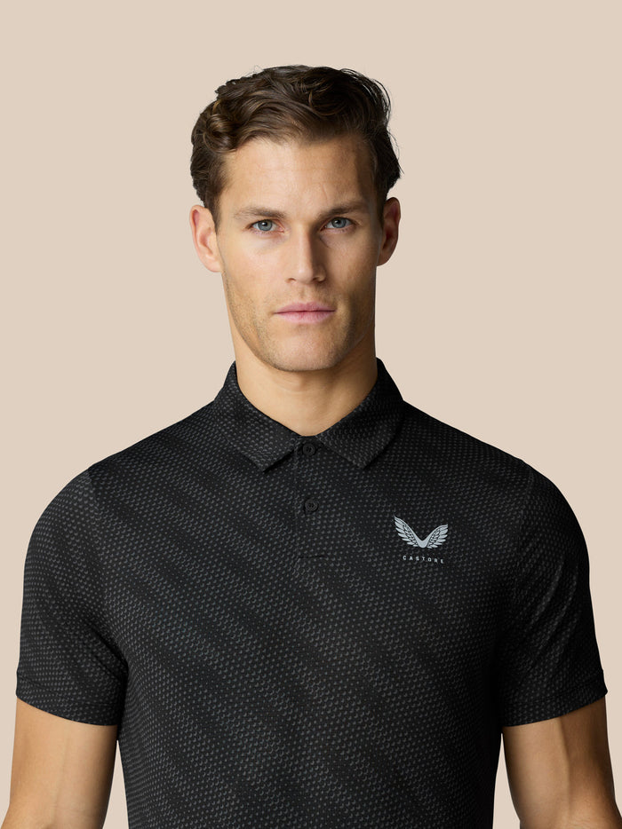 Close up of male model wearing black Club Graphic Polo with small chest logo.