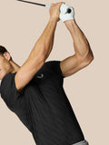 Male model wearing black Club Graphic Polo with golf ball print ready to swing a golf club