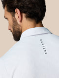 Back view of a white textured polo with CASTORE wordmark along the upper back.