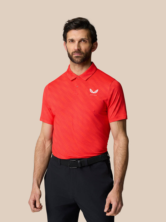 Man wearing a bright red poppy polo with a subtle golf ball pattern and white logo on the chest
