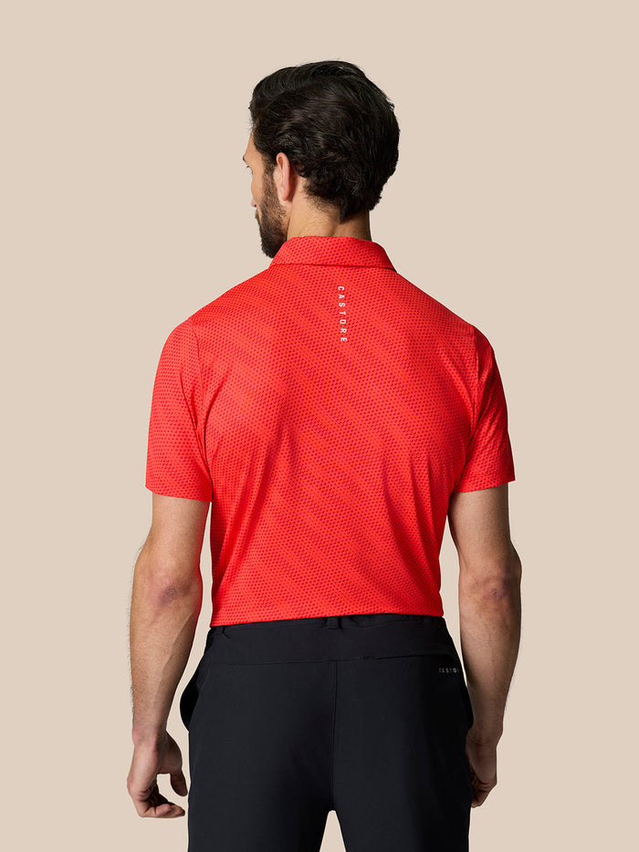 Back view of a man wearing a red golf polo with golf ball print and Castore branding
