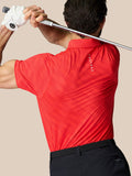Rear view of a man in a red dotted polo with Castore branding on the upper back