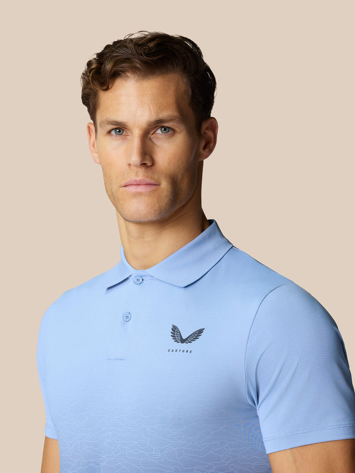 Male model wearing sky blue Club Graphic Polo with Castore logo on chest and ombre detail.