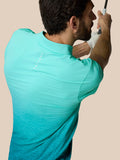 Back view of a man in a light aqua Club Graphic Polo with an ombre pattern and Castore branding along the upper back