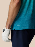 Close-up of the Club Graphic Polo hem on teal fabric showing the light aqua ombre pattern and AERTEK branding near the side slit.