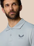 Upper body shot of a man in a light blue polo featuring a subtle gradient and the Castore logo on the left chest.