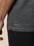 Close-up of the polo’s lower back showing the abstract squiggle print on dark fabric with AERTEK branding on the shorts.